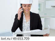 beatiful woman engineer with plans papers on building site. Стоковое фото, агентство Ingram Publishing / Фотобанк Лори