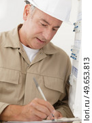 portrait of electrician standing next to fuseboard. Стоковое фото, агентство Ingram Publishing / Фотобанк Лори