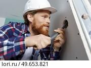 young electrician installer working with cable. Стоковое фото, агентство Ingram Publishing / Фотобанк Лори