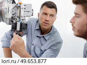 ophthalmologist examining young man with optometric machine. Стоковое фото, агентство Ingram Publishing / Фотобанк Лори