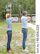 man and woman aiming towards archery target. Стоковое фото, агентство Ingram Publishing / Фотобанк Лори