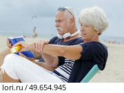 senior couple on the beach woman applying suncream. Стоковое фото, агентство Ingram Publishing / Фотобанк Лори