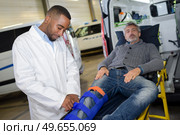 Man on stretcher, leg in splint. Стоковое фото, агентство Ingram Publishing / Фотобанк Лори