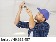 technician installing surveillance camera in the house carport. Стоковое фото, агентство Ingram Publishing / Фотобанк Лори