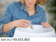 asian woman changing light bulb. Стоковое фото, агентство Ingram Publishing / Фотобанк Лори