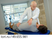 chiropractor examine the patient's spine. Стоковое фото, агентство Ingram Publishing / Фотобанк Лори