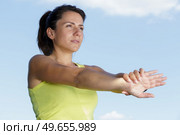 woman exercising outdoors stretching her arms forwards. Стоковое фото, агентство Ingram Publishing / Фотобанк Лори