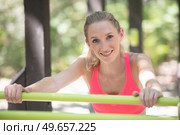 young fitness woman leaning to wall bars outdoors. Стоковое фото, агентство Ingram Publishing / Фотобанк Лори