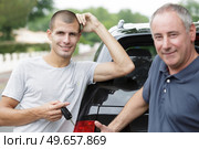 young male white driver is holding new car key. Стоковое фото, агентство Ingram Publishing / Фотобанк Лори