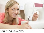 portrait of young woman threading sewing machine. Стоковое фото, агентство Ingram Publishing / Фотобанк Лори