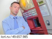 tired man next to a vending machine. Стоковое фото, агентство Ingram Publishing / Фотобанк Лори
