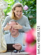 woman surprising man by covering his eyes from behind. Стоковое фото, агентство Ingram Publishing / Фотобанк Лори