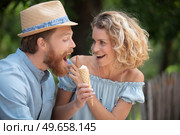 flirtatious couple in the park sharing an ice-cream. Стоковое фото, агентство Ingram Publishing / Фотобанк Лори
