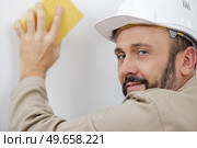 man sanding wall with sandpaper. Стоковое фото, агентство Ingram Publishing / Фотобанк Лори