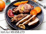 Meat steak barbecue cooked in oranges. Cutting in slices flank steak. Meat in citrus marinade. Meat steak fried with citrus fruits. Стоковое фото, агентство Ingram Publishing / Фотобанк Лори