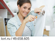 young woman is assembling a cupboard at home. Стоковое фото, агентство Ingram Publishing / Фотобанк Лори
