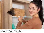 woman cleaning dust from bookshelf. Стоковое фото, агентство Ingram Publishing / Фотобанк Лори