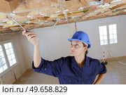 woman inspecting wooden timbers on renovation site. Стоковое фото, агентство Ingram Publishing / Фотобанк Лори