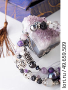 stylish jewelry bracelet with semiprecious and amethyst  crystal around  white background. hobby and fashion concept. close up. Стоковое фото, агентство Ingram Publishing / Фотобанк Лори