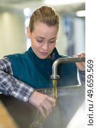 woman filling glass with beer from tap filling vat. Стоковое фото, агентство Ingram Publishing / Фотобанк Лори