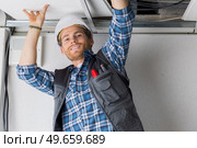 electrical worker wiring in ceiling. Стоковое фото, агентство Ingram Publishing / Фотобанк Лори