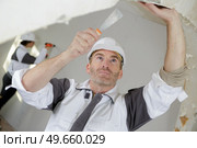 portrait of builder removing the wallpaper. Стоковое фото, агентство Ingram Publishing / Фотобанк Лори