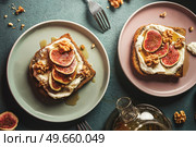 Breakfast french toasts with cream fresh, fig slices and nuts, drenched in maple syrup on plates , top view. Стоковое фото, агентство Ingram Publishing / Фотобанк Лори