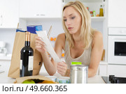 a woman is checking shopping list. Стоковое фото, агентство Ingram Publishing / Фотобанк Лори
