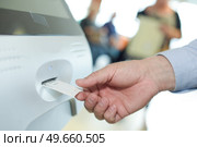 man getting a ticket from a machine. Стоковое фото, агентство Ingram Publishing / Фотобанк Лори