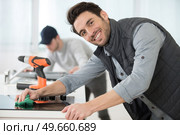 young male repairman repairing oven in kitchen. Стоковое фото, агентство Ingram Publishing / Фотобанк Лори