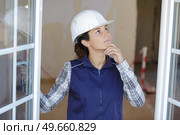 pensive female worker inspecting new windows. Стоковое фото, агентство Ingram Publishing / Фотобанк Лори