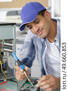 man soldering printed circuit board of disassembled faulty pc. Стоковое фото, агентство Ingram Publishing / Фотобанк Лори