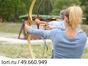 Woman and man practicing archery. Стоковое фото, агентство Ingram Publishing / Фотобанк Лори