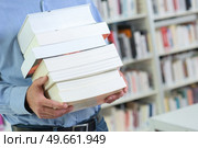 man holds a pile of books. Стоковое фото, агентство Ingram Publishing / Фотобанк Лори