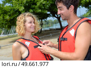 boyfriend helping his girlfriend button her safety jacket. Стоковое фото, агентство Ingram Publishing / Фотобанк Лори