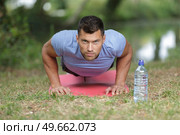 strapping young lad doing pushups in park. Стоковое фото, агентство Ingram Publishing / Фотобанк Лори