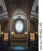 Louvre Palace symmetric architectural details of a hall with stone staircase, ornate railings, different corridors and a clock type window in center, Paris, France. Стоковое фото, агентство Ingram Publishing / Фотобанк Лори
