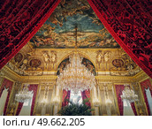 Beautiful decorated Napoleon apartments at Louvre palace. Royal family rooms with cardinal red curtains, golden ornate walls, paintings and crystal chandeliers suspended from ceiling. Стоковое фото, агентство Ingram Publishing / Фотобанк Лори
