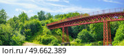 Red bridge in green nature with a river stream beneath in the summer. Стоковое фото, агентство Ingram Publishing / Фотобанк Лори