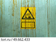 Chemical warnings sign on a wall with fluids leaking down the metal surface. Стоковое фото, агентство Ingram Publishing / Фотобанк Лори
