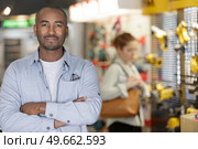 worker man in hardware store is trading sockets and switches. Стоковое фото, агентство Ingram Publishing / Фотобанк Лори