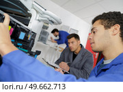 doubting man fixing copier in the office. Стоковое фото, агентство Ingram Publishing / Фотобанк Лори