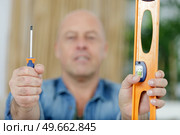 a positive man showing tools. Стоковое фото, агентство Ingram Publishing / Фотобанк Лори