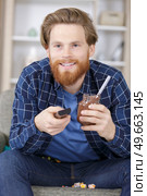 man eating sugary snacks while watching tv. Стоковое фото, агентство Ingram Publishing / Фотобанк Лори