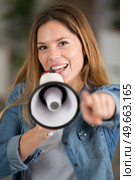 woman pointing forwards while speaking through megaphone. Стоковое фото, агентство Ingram Publishing / Фотобанк Лори