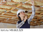 young female builder working on ceiling joist. Стоковое фото, агентство Ingram Publishing / Фотобанк Лори