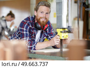 carpenter adjusting blade on bench saw. Стоковое фото, агентство Ingram Publishing / Фотобанк Лори