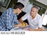 electrician apprentice using multimeter teacher monitoring. Стоковое фото, агентство Ingram Publishing / Фотобанк Лори