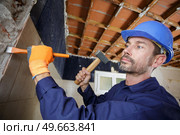 man hammers into the wall. Стоковое фото, агентство Ingram Publishing / Фотобанк Лори