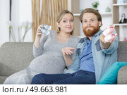 happy couple showing baby shoes. Стоковое фото, агентство Ingram Publishing / Фотобанк Лори